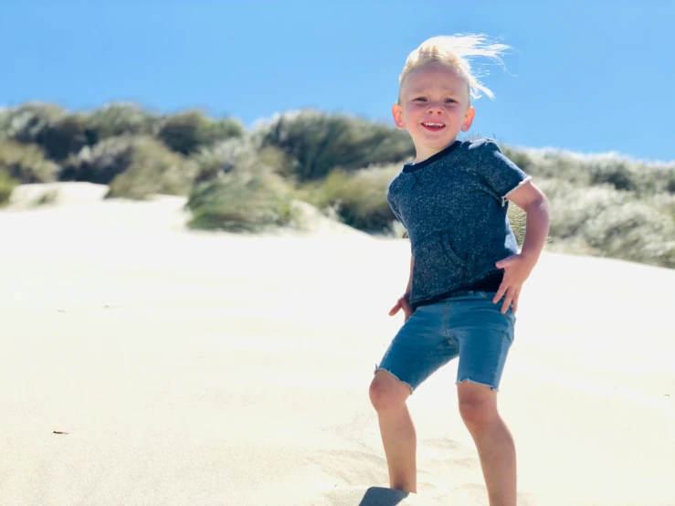 the  stands in the sand and smiles