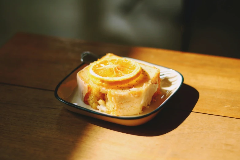 a dessert dish of orange slices and lemon on a table