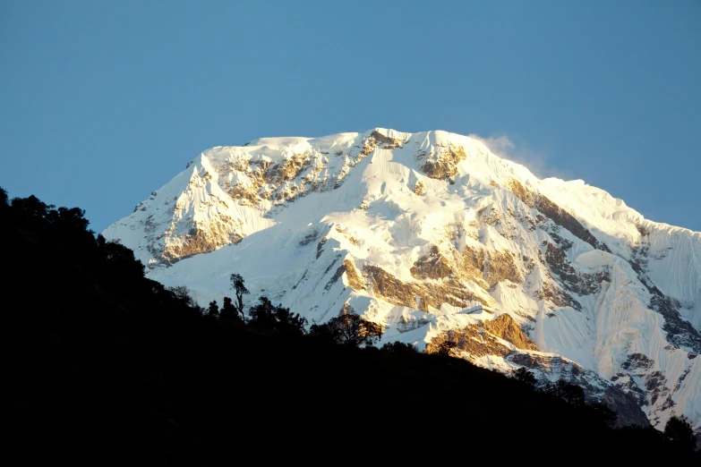 the top of a mountain covered in snow with a bright sun