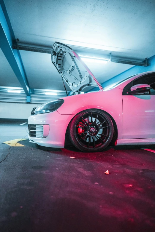 a car in a parking garage with its hood open