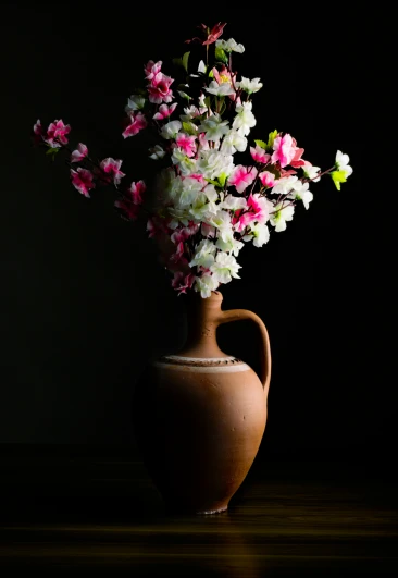 an asian vase holds different colored flowers
