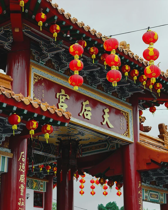 a chinese building with red columns and lanterns attached to the roof