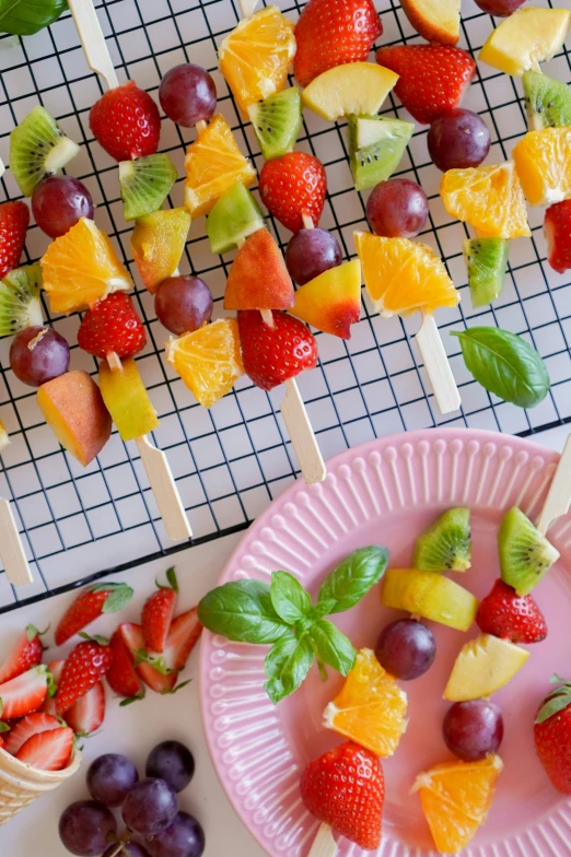 the tray has fruits and skewers on them on skewers, and other fruit on skewers