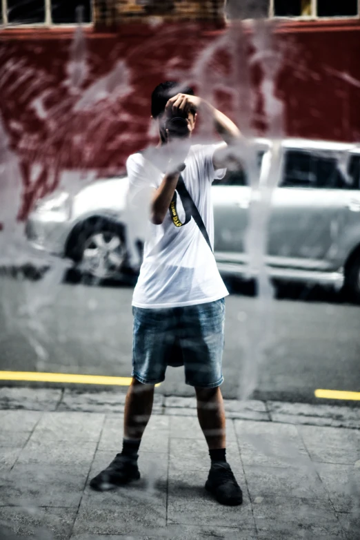 a man is holding his hands up as he looks at cars