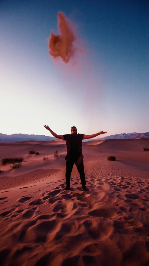 a man in the desert holding his arms out