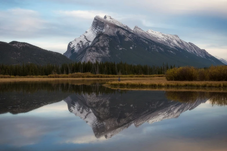 a mountain reflects in the still waters of a lake