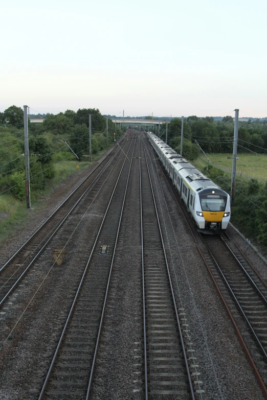 a passenger train traveling down tracks through a rural country side