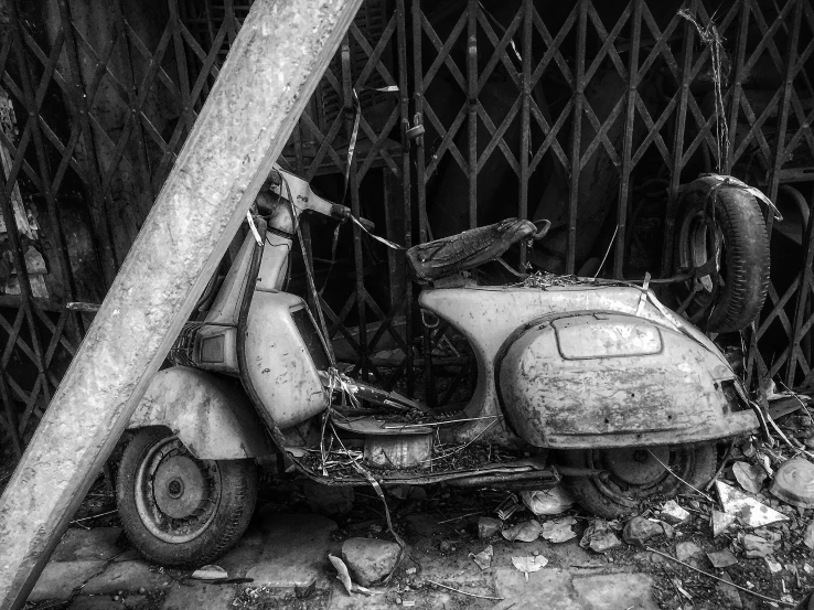 an old motorbike parked near a wooden fence