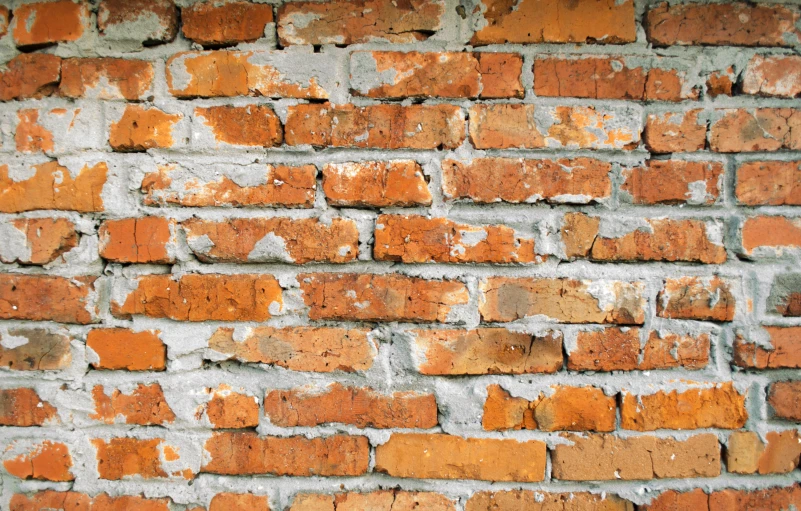 an orange and white wall with old red bricks