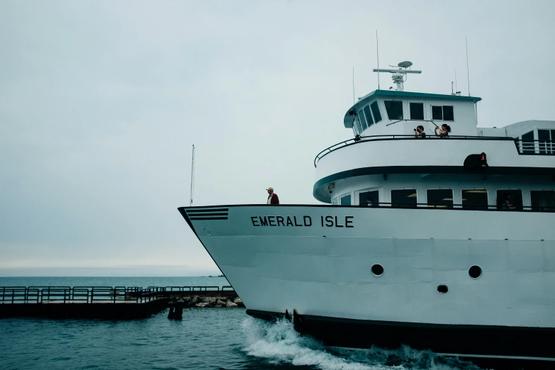 a large boat traveling down the water near a dock