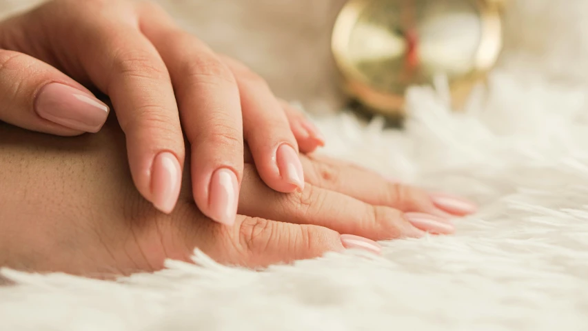 a woman's hand and manicured fingernails on her leg