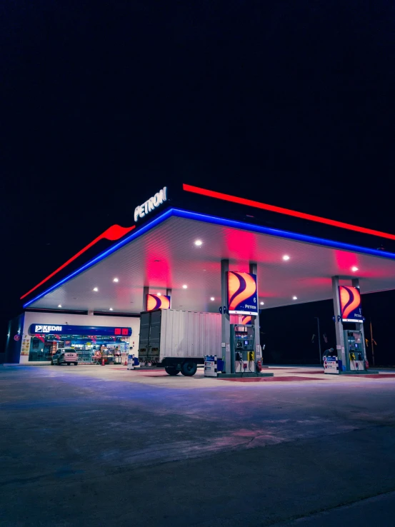 a gas station with gas pumps at night time