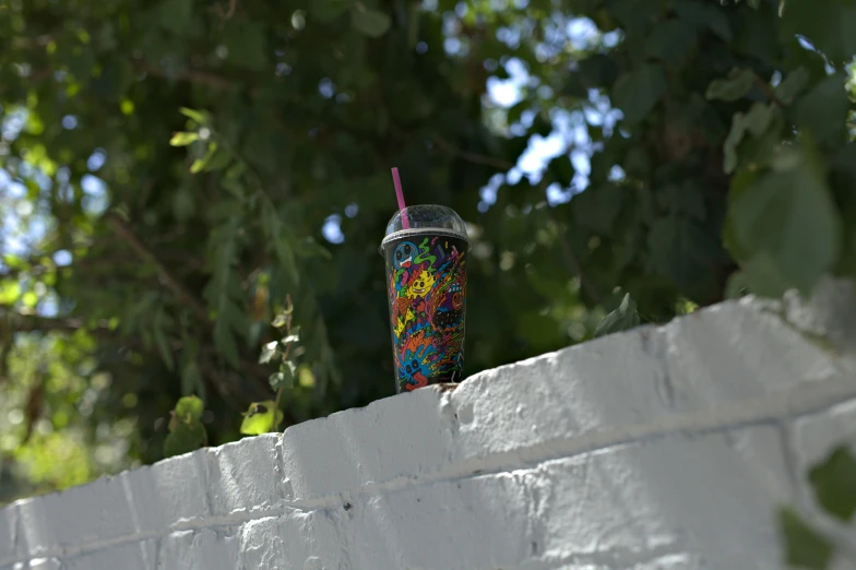 a cup with colorful beads, and straw stuck to the outside