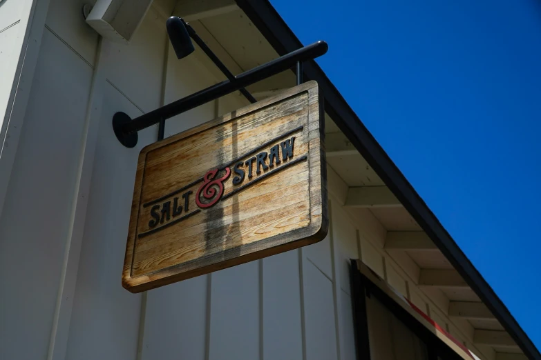 a storefront with an old fashioned sign hanging from it