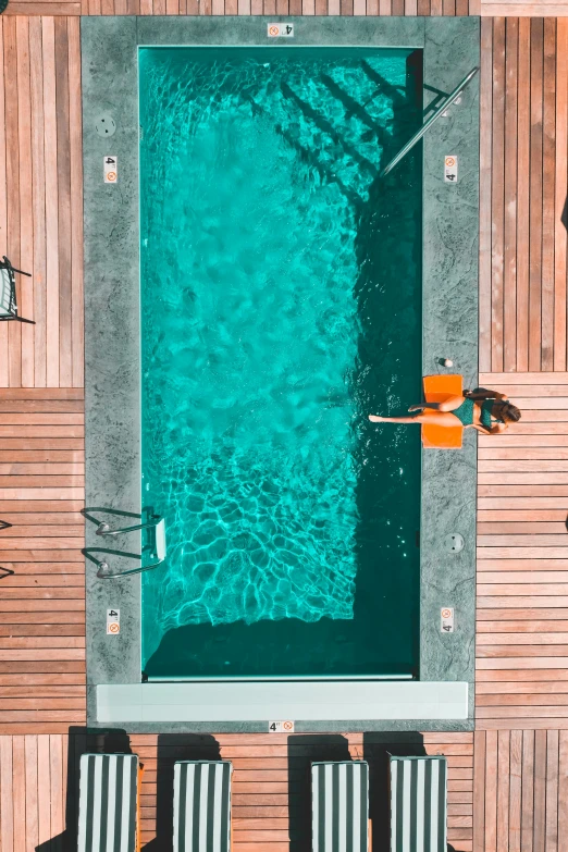 an empty swimming pool surrounded by wood benches