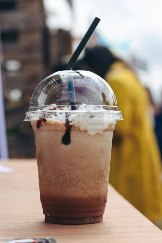 a paper cup with a straw is on the table