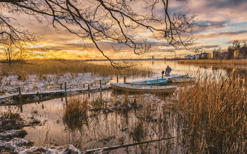 a boat sitting in a snowy lake near a field