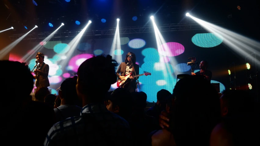 a stage show with a man playing the guitar on a stage surrounded by people