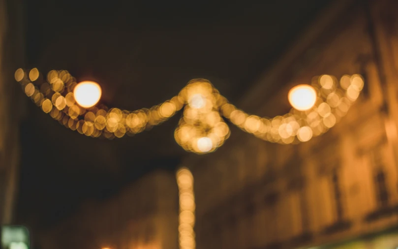 the lights are hanging over the street near a building