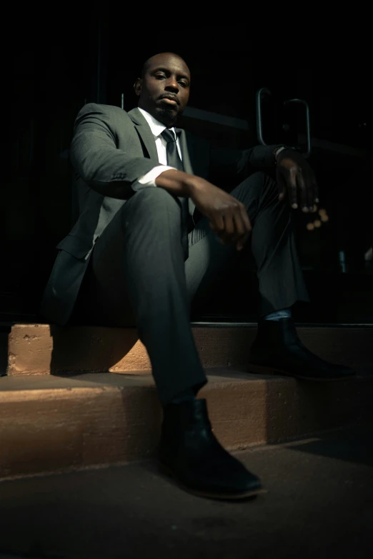 a man in suit sitting on stairs at night