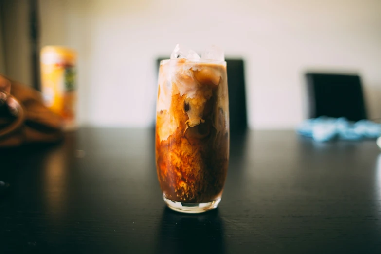 an iced drink with a piece of fruit sits on the table