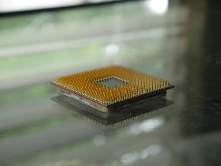 a small gold processor on top of a glass table