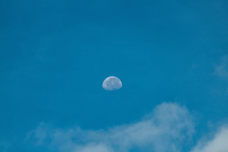 the full moon is seen in the sky over a cloud filled sky