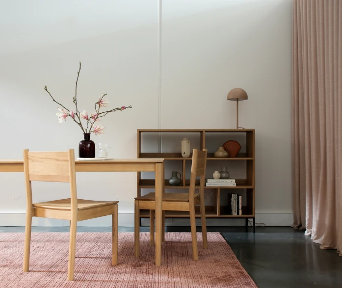 a light wooden table and chairs in a room