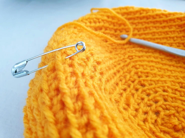 close up image of knitting stitchs and needles