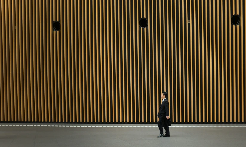 a man standing in front of an odd shaped wall