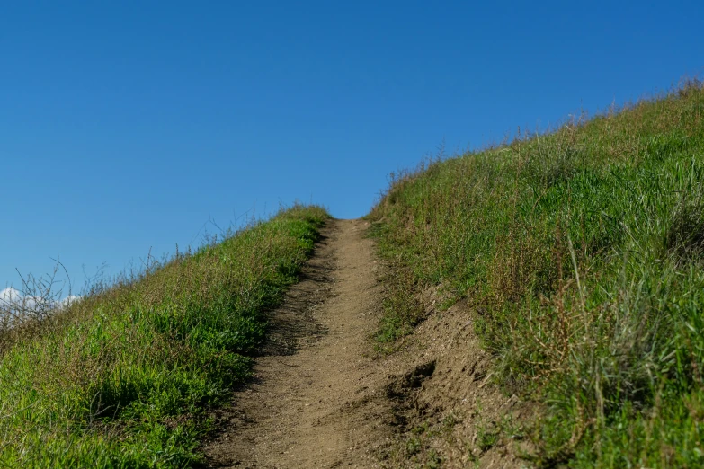 the dirt path goes down to the top of the hill