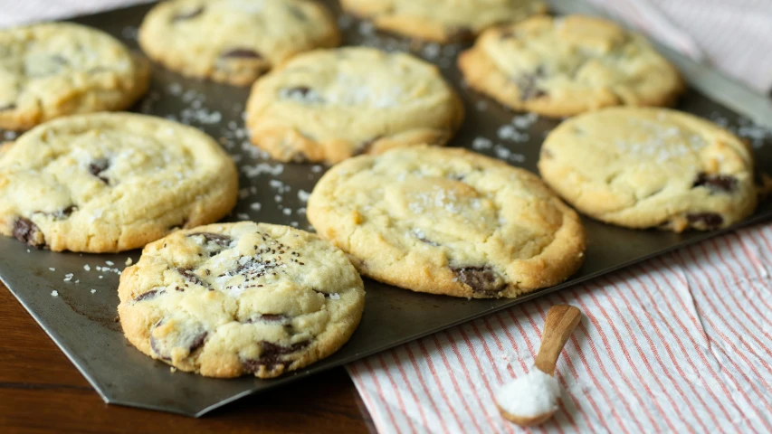 a cookie sheet with nine chocolate chip cookies on it