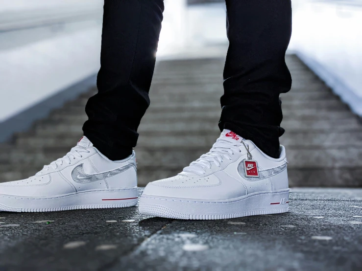 there is a man with white and red sneakers standing on a stairway