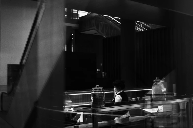 a woman sits at a desk in front of a mirror