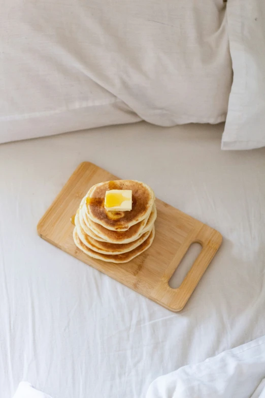 four stacked pancakes with er are on a bed