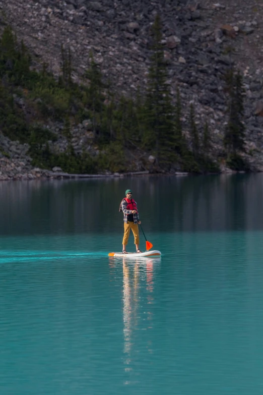 a man riding a paddle board on top of a lake