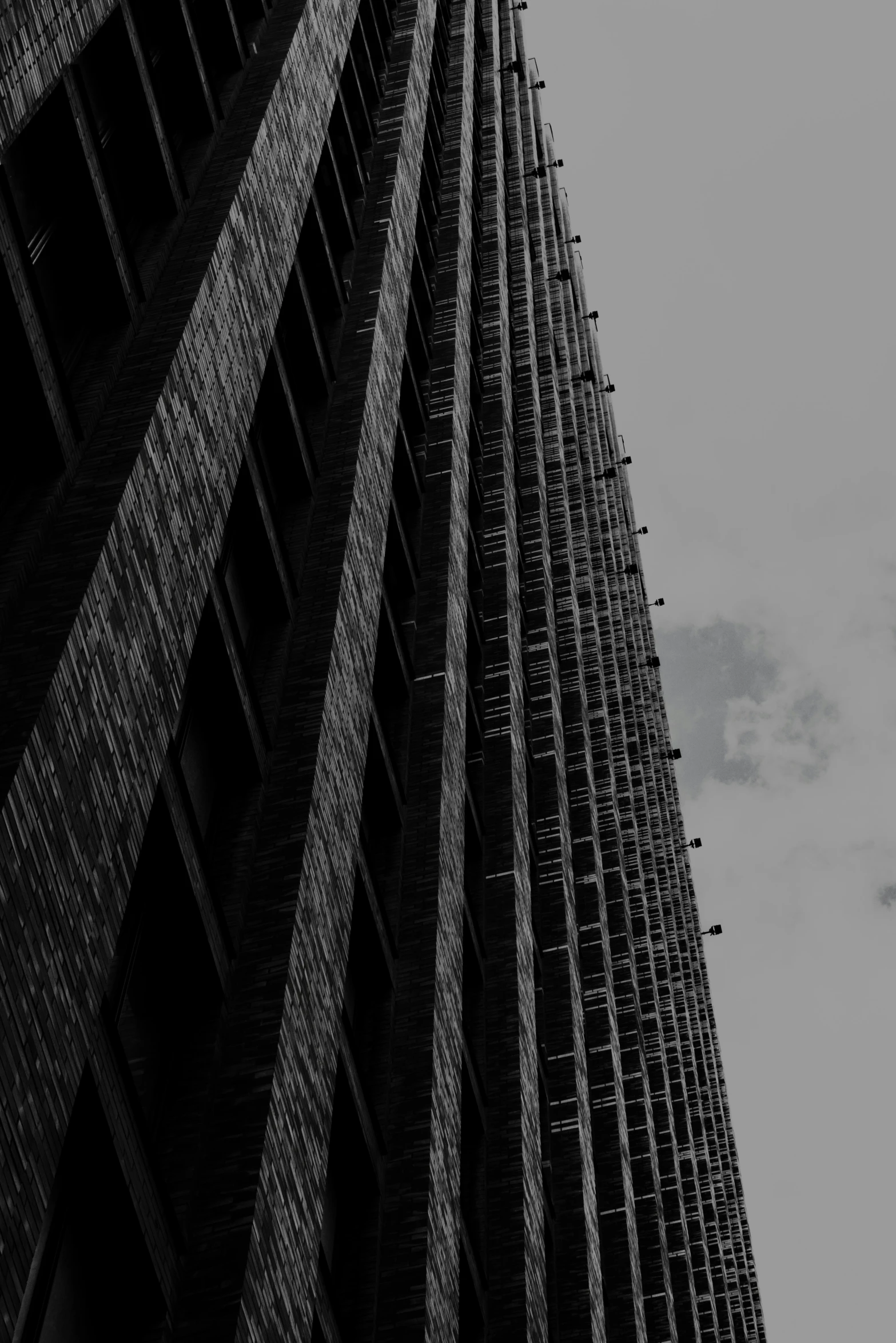 a black and white image of a building with the sky in the background