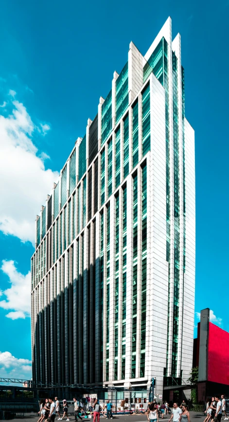 people on bicycles move by a large building