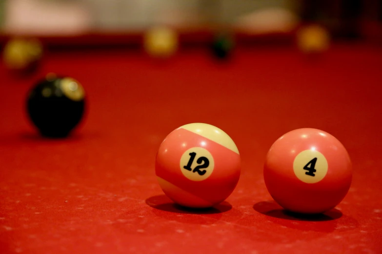 three pool balls that are sitting on a red surface