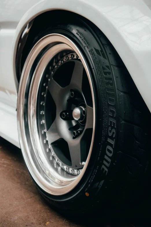 the back tire of a white car on a brown ground