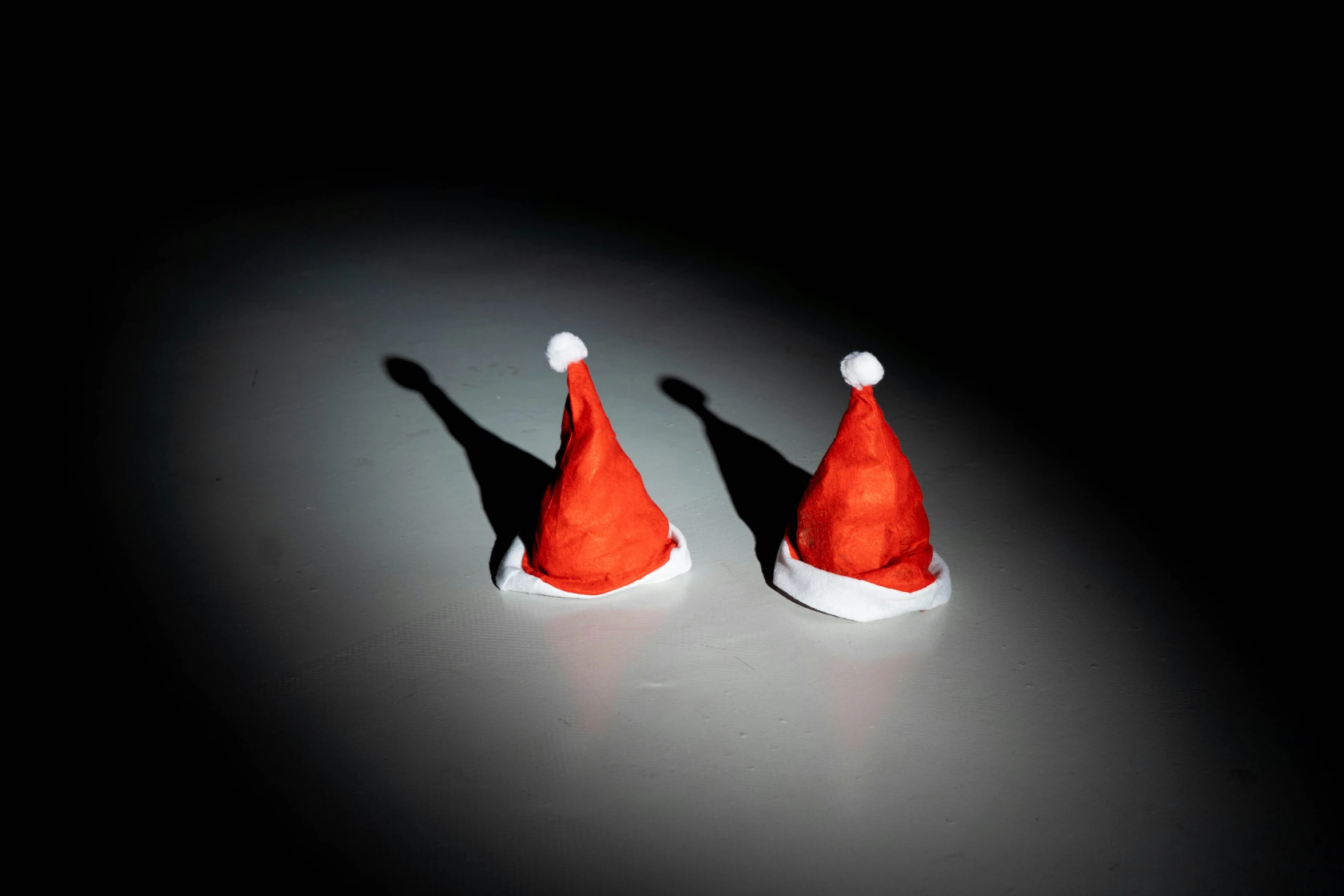 a close up of two small orange santa hats