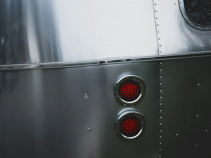 two traffic lights sitting in front of a silver car