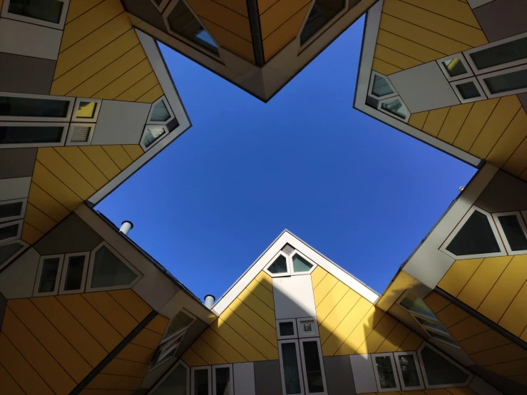 looking up at multi - level buildings with the blue sky