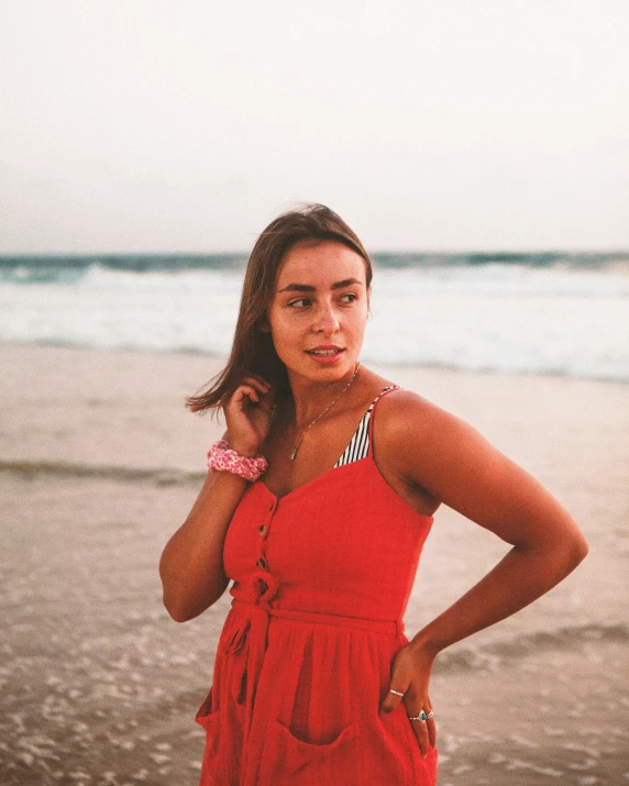 there is a girl on the beach posing for a picture