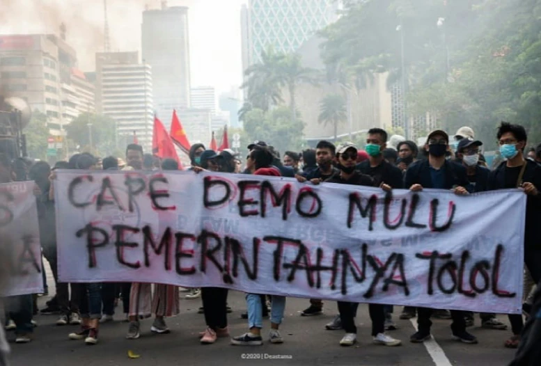 some protesters holding a large sign during a protest