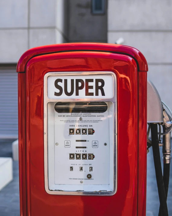 a red telephone on the street with a sign stating it is super