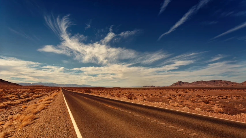 a lone highway goes into a beautiful, deserted desert