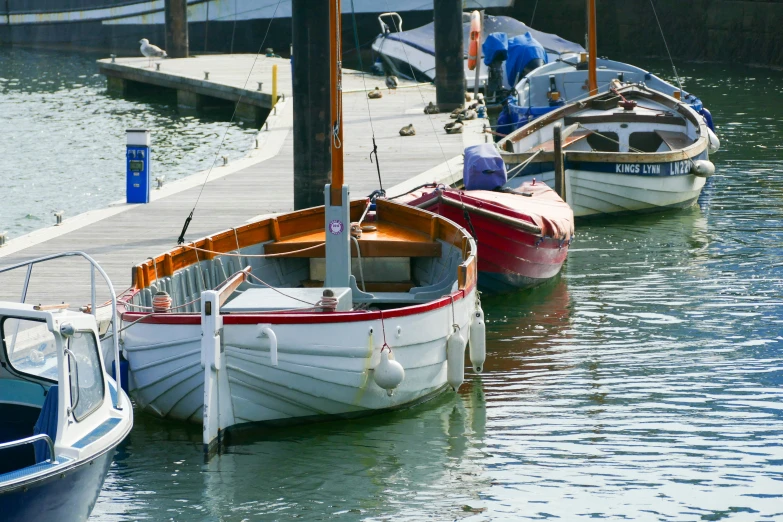 three boats parked next to a dock in the water