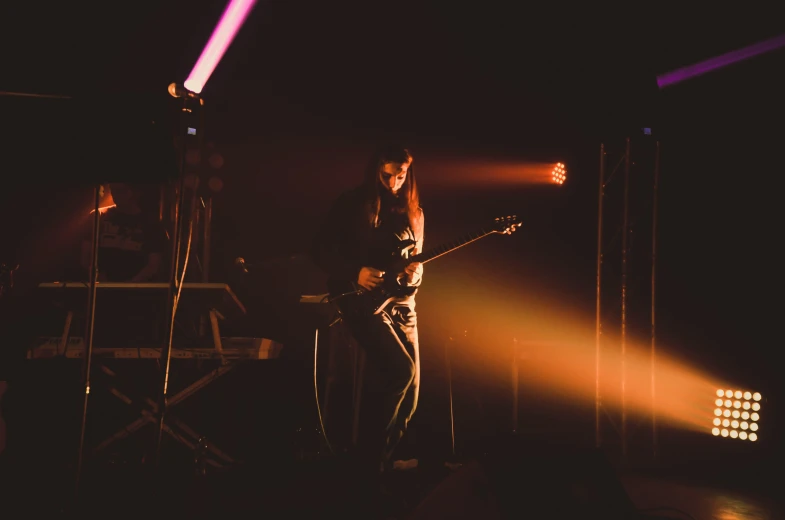 a guy plays his guitar in the dark