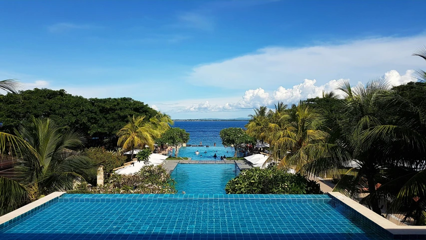 a view from inside a resort looking out on to a blue pool